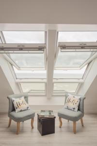 梅利蒙Les Chambres d'Hôtes de la Mer的客房设有两把椅子和天窗天花板。