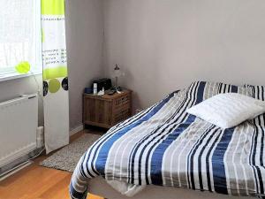 博尔奈斯Holiday home BOLLNÄS的一间卧室配有一张带蓝白条纹毯子的床