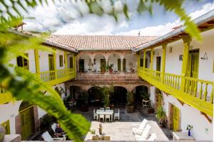 库斯科梅洛克尼诺斯酒店的一座拥有黄色装饰和庭院的古老房子