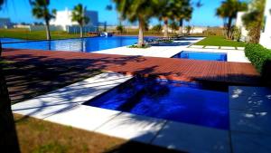 尚格里拉CASA EM CONDOMÍNIO - 3 dormitórios - LAZER COMPLETO - Xangri-lá的一座拥有蓝色海水和棕榈树的游泳池