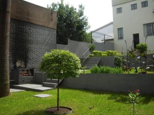 南卡希亚斯Casa do Rogerio Hostel - Unidade Shopping的庭院中间有树的花园