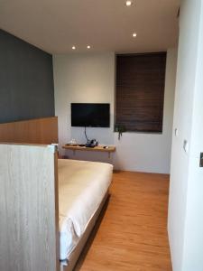 恒春古城垦丁浅水蓝的一间卧室配有一张床和一台平面电视