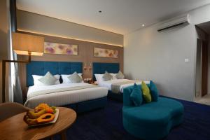 达沃市Blue Lotus Hotel的酒店客房,配有两张床、一张桌子和一把椅子