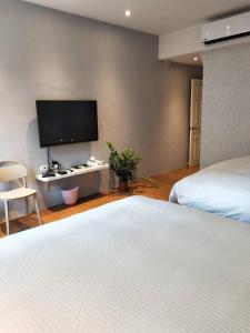 恒春古城垦丁浅水蓝的一间卧室配有两张床和一台平面电视
