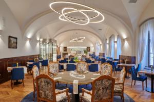 伏尔塔瓦河畔赫卢博卡什特克尔酒店的一间带桌椅和吊灯的用餐室