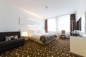 慕尼黑拜耳酒店的酒店客房,配有床和沙发