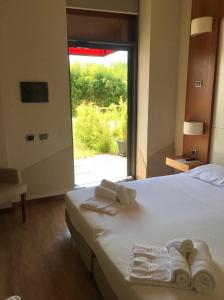 皮内罗洛芭拉吉酒店的一间卧室配有带毛巾的床和窗户。
