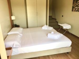 皮内罗洛芭拉吉酒店的一张白色大床,上面有毛巾