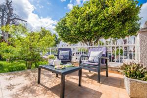 阿尔库迪亚港Ideal Property Mallorca - Villa Celia的庭院配有两把椅子和一张桌子