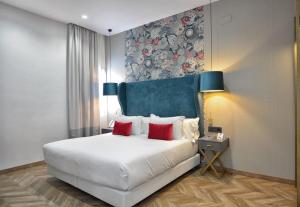 塞维利亚Soho Boutique Sevilla的卧室配有带红色枕头的大型白色床
