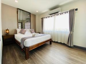 清迈Ç精品舒适酒店 的一间卧室设有一张床和一个大窗户