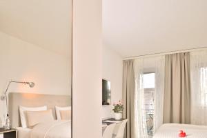 克罗伊茨林根六号酒店 的一间卧室配有两张床和镜子