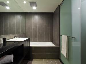 台北富驛時尚酒店 - 南京東路館的带浴缸和盥洗盆的浴室