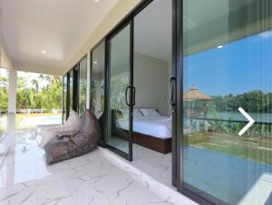 素叻Suan Son Villa Koh Sa Nher สวนสนธิ์วิลล่า เกาะเสนอ SHA的一间卧室设有一张床和一个大型玻璃窗
