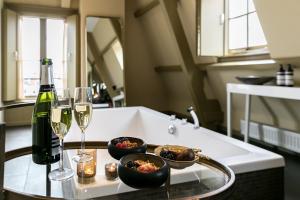 哈莱姆布莱斯套房酒店的一张桌子,上面放着两杯酒和一瓶葡萄酒