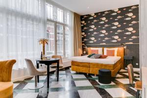 哈莱姆布莱斯套房酒店的一间卧室配有一张床、一张桌子和一个窗户。