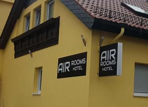 克尔斯特尔巴赫Air Rooms Hotel的一座黄色的建筑,上面有空气调节室的标志