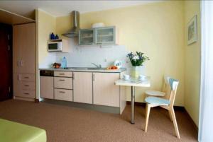 查普伊Villa Baltic - Apartament Chałupy nr 6的厨房配有桌子、水槽和椅子