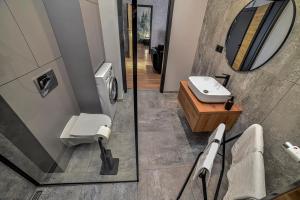 新苏尔Portowa Art的一间带卫生间、水槽和镜子的浴室