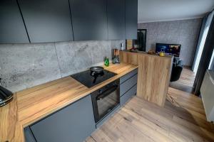 新苏尔Portowa Art的厨房配有木制柜台和炉灶烤箱。