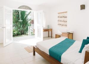 拉斯特拉纳斯El Mosquito Boutique Hotel Playa Bonita的一间卧室设有一张床和一个开放式门