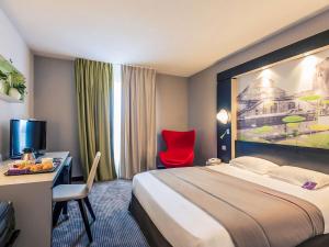 尼奥尔尼奥尔马莱波特温美居酒店的酒店客房配有一张床、一张桌子和一把红色椅子