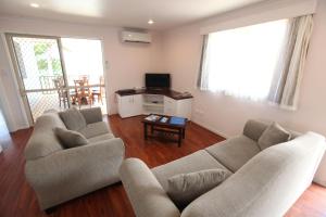 拉罗汤加莫阿纳沙滩别墅公寓的客厅配有两张沙发和一台电视