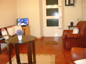 GinetesCasa d'Amália的客厅配有桌子、沙发和电视