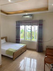 内排Nhà Nghỉ Diễm Quỳnh的一间卧室设有一张床和一个窗口