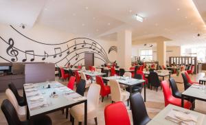 彰化市彰化福泰商务饭店的用餐室配有桌子和红色椅子