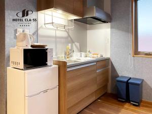 广岛HOTEL CLA-SS HIROSHIMA-OZU的厨房配有冰箱上方的微波炉