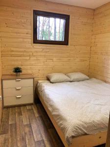 博茨科沃Świerkowy domek的一间卧室设有一张床和一个窗口