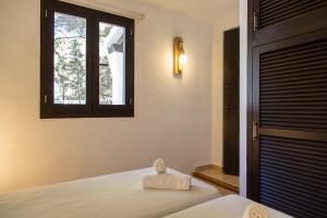 埃斯卡洛诺维公寓酒店的一间卧室配有一张带窗户和毛巾的床