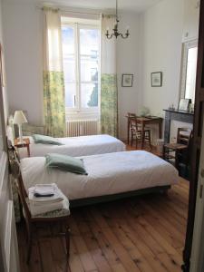 昂热Chambre d'Hôtes Marchand的一间卧室设有两张床、一张桌子和一个窗口