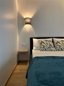 考纳斯COZY Nest apartment in Kaunas的卧室配有一张床,墙上有灯