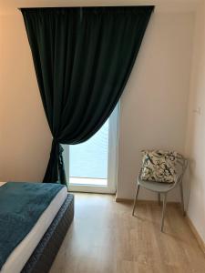 考纳斯COZY Nest apartment in Kaunas的卧室配有床、椅子和窗户。