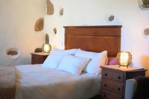 圣巴托洛梅Finca Mariola - Alpendre的一间卧室配有一张带两张台灯的床铺。