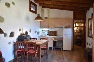 圣巴托洛梅Finca Mariola - Alpendre的厨房配有桌椅和冰箱。