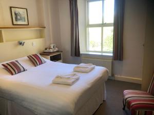 帕特代尔布拉舍斯沃特宾馆的卧室配有带2条毛巾的窗户,位于床上