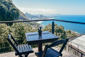 里约热内卢米兰特托亚维莱酒店的阳台配有一张桌子和两把椅子,享有海景