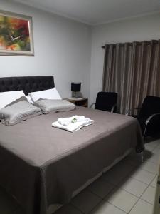 阿拉萨图巴Hotel Athenas e Convenções的一间卧室配有一张床,床上有毛巾