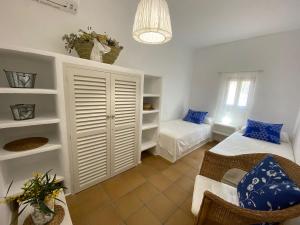 米乔尔海滩Can Miguel Marti - Astbury Formentera的一间卧室配有两张床和一张沙发。
