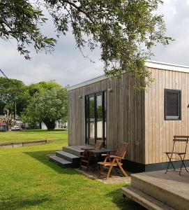 AlphenTiny House by the water - de Schans Alphen的一间小房子,配有野餐桌和椅子