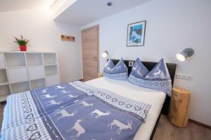 克里姆尔Ferienwohnung Trocker的一间卧室配有一张带蓝色和白色毯子和枕头的床。