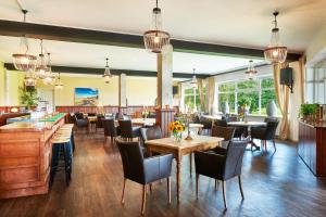 Tiendeveen马特斯普列克酒店的餐厅设有桌椅和窗户。