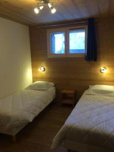 阿尔克河畔博讷瓦勒La Datcha*** 4-5 personnes的一间卧室设有两张床和窗户。
