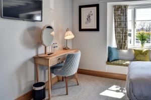 牛顿阿伯特Barn Owl Inn的一间卧室配有一张带镜子的桌子和一张床