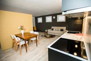 索斯特appartement - sauna - natuur - Utrecht的厨房以及带桌椅的起居室。