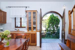帕纳基雅Villa Nina的开放式厨房配有桌子和拱门