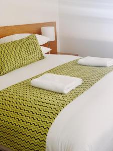 布罗肯希尔红地球汽车旅馆 的两张带黄白色床单和枕头的床